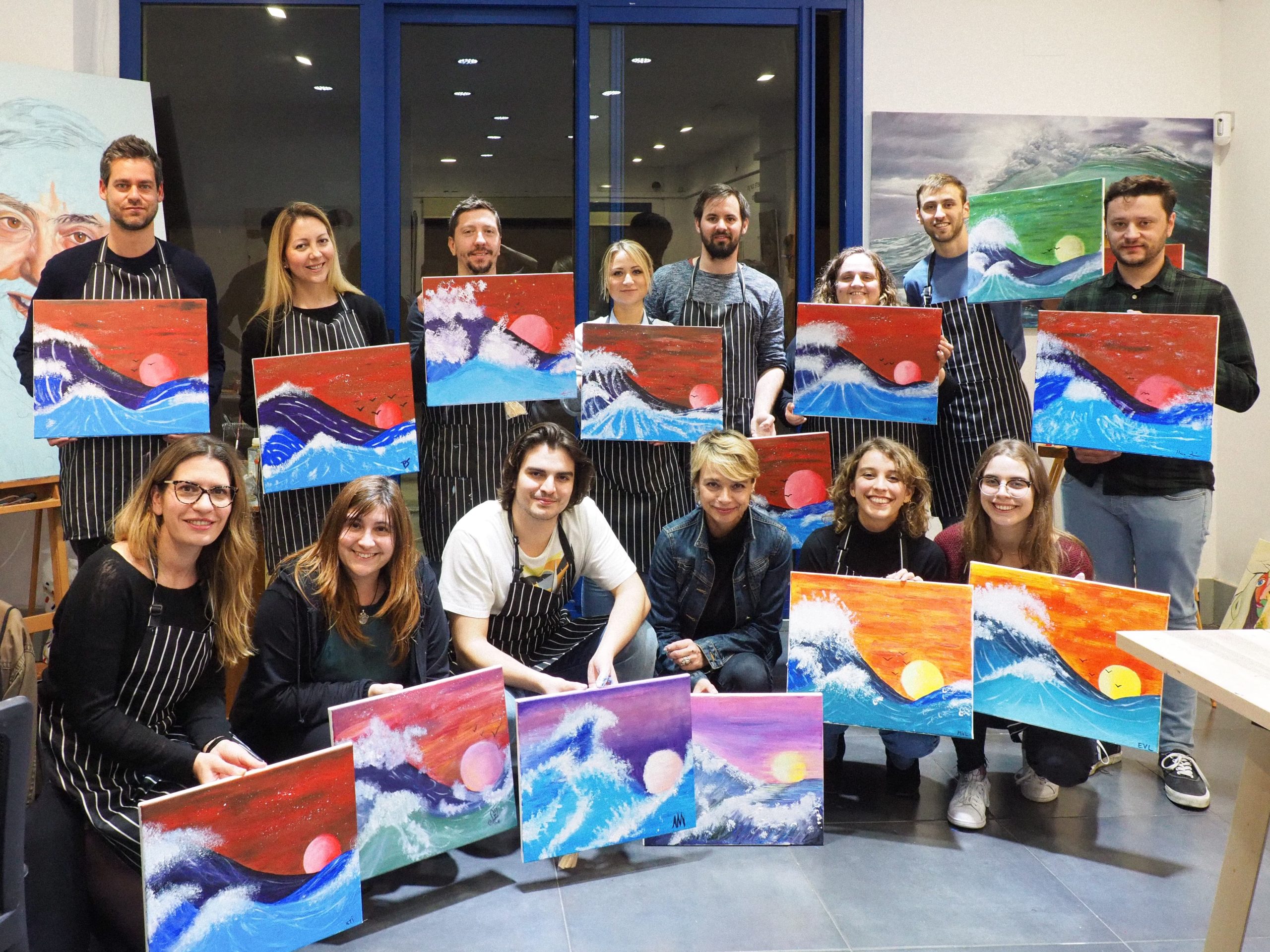 work team showing their finished paintings after the teambuilding session